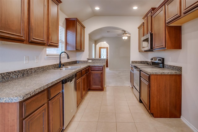 kitchen with lofted ceiling, sink, light tile patterned floors, ceiling fan, and appliances with stainless steel finishes