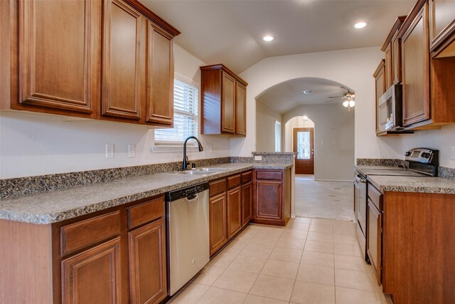 kitchen with lofted ceiling, sink, light tile patterned floors, appliances with stainless steel finishes, and ceiling fan