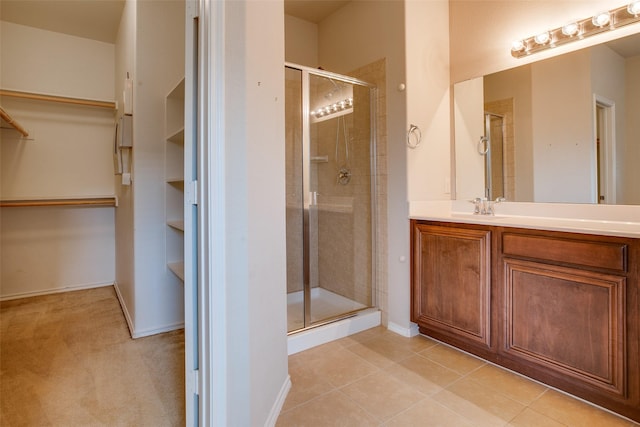 bathroom with vanity, an enclosed shower, and tile patterned flooring