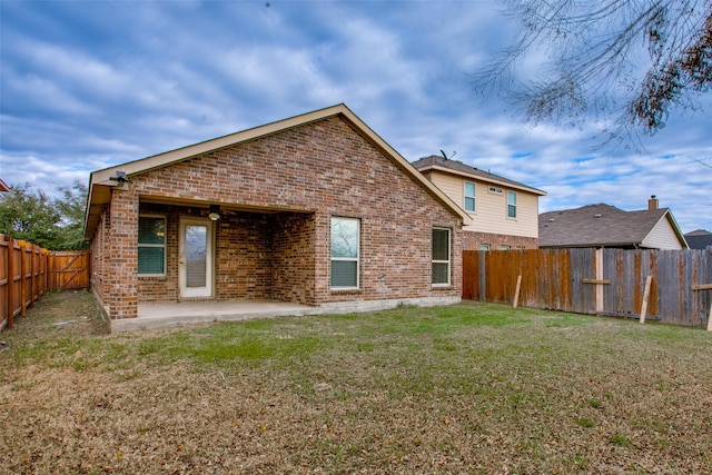 back of house with a patio and a lawn