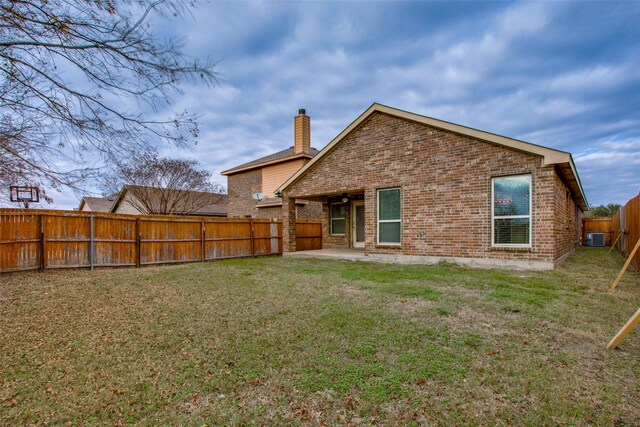 rear view of house with a yard, a patio area, and central air condition unit