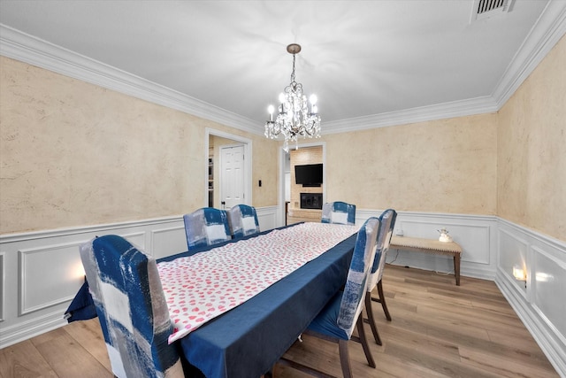 dining room with crown molding, a chandelier, and light wood-type flooring