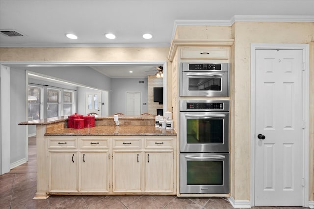 kitchen featuring crown molding, light stone countertops, and stainless steel double oven