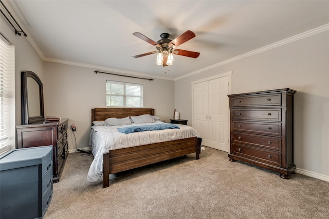 carpeted bedroom featuring crown molding, ceiling fan, and a closet