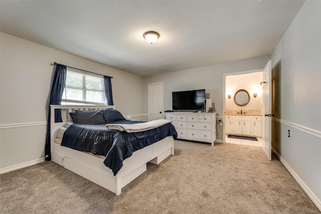 carpeted bedroom with connected bathroom and sink