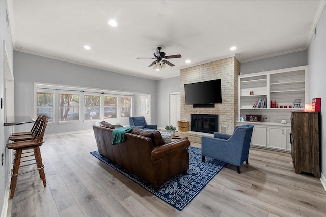 living room with ornamental molding, a fireplace, and light hardwood / wood-style flooring