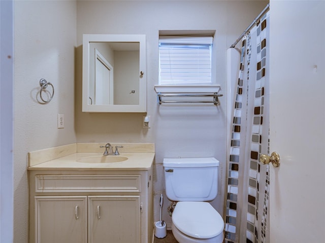 bathroom featuring vanity, toilet, and curtained shower