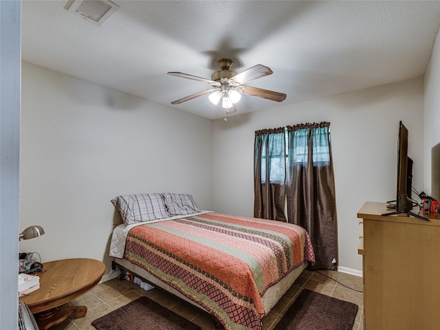 bedroom featuring light tile patterned floors, a textured ceiling, and ceiling fan