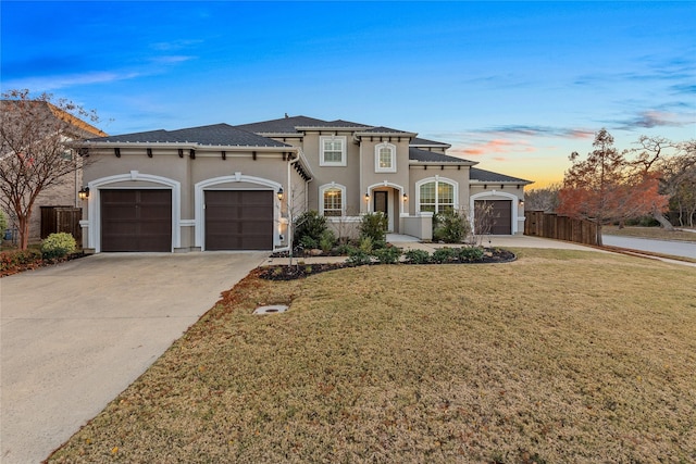 mediterranean / spanish-style house featuring a garage and a lawn