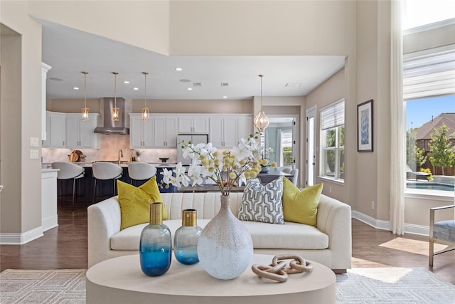 living room featuring wood finished floors, recessed lighting, and baseboards