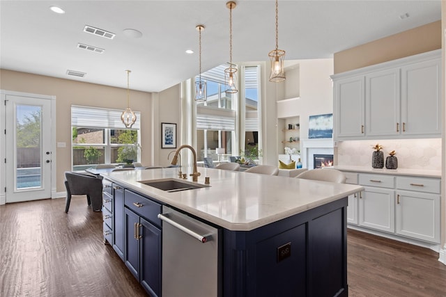 kitchen with white cabinetry, visible vents, stainless steel dishwasher, and a sink