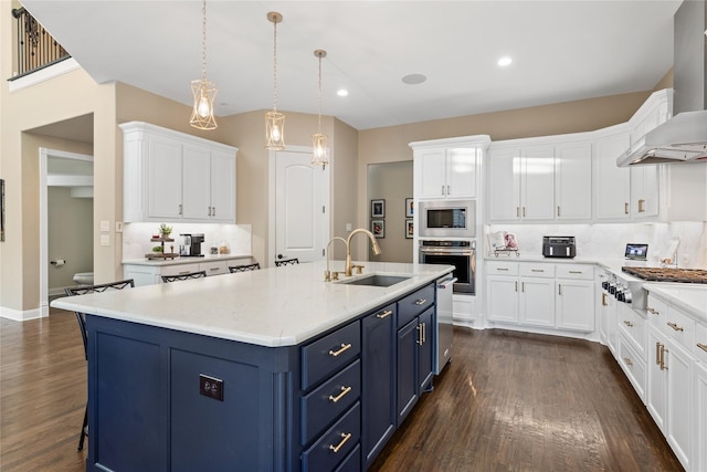 kitchen featuring white cabinetry, wall chimney exhaust hood, stainless steel appliances, and blue cabinets