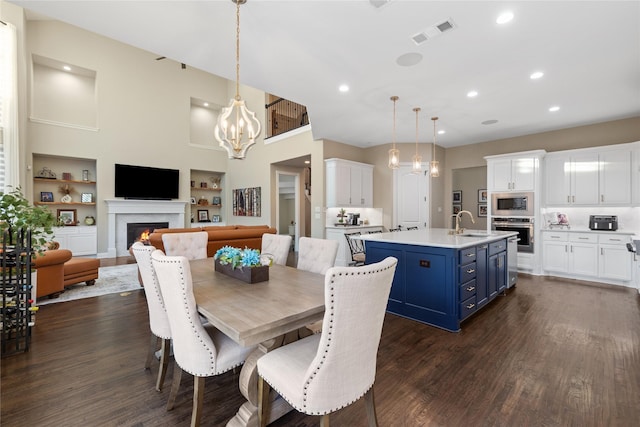 dining space with built in features, a high ceiling, dark hardwood / wood-style floors, and sink