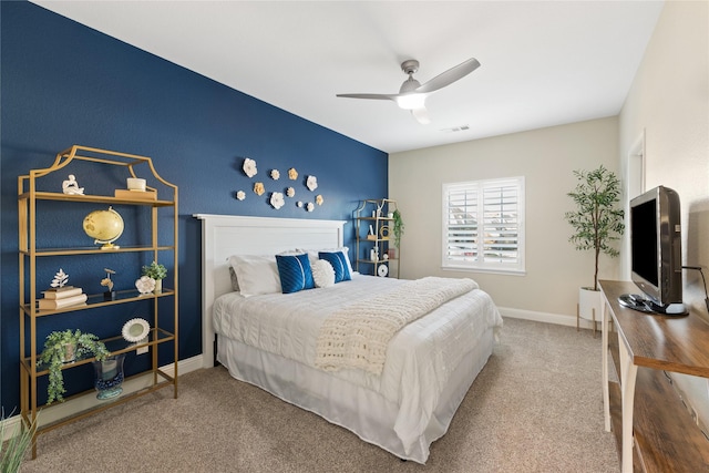 carpeted bedroom with a ceiling fan, visible vents, and baseboards