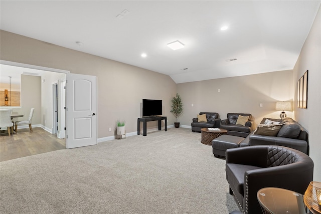 living room featuring light colored carpet and vaulted ceiling