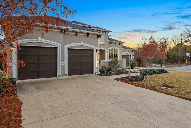 mediterranean / spanish-style home with a lawn and a garage