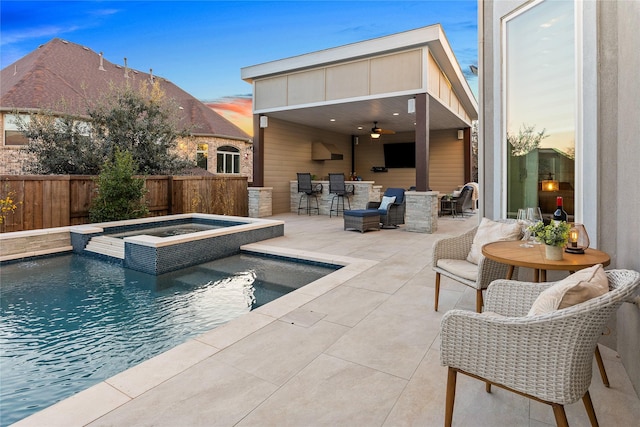 exterior space featuring a fenced backyard, a patio area, a ceiling fan, a bar, and a pool with connected hot tub