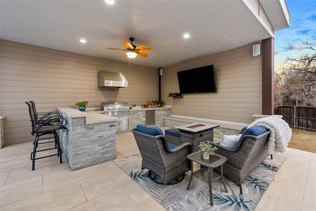 view of patio featuring an outdoor fire pit, grilling area, exterior bar, fence, and area for grilling