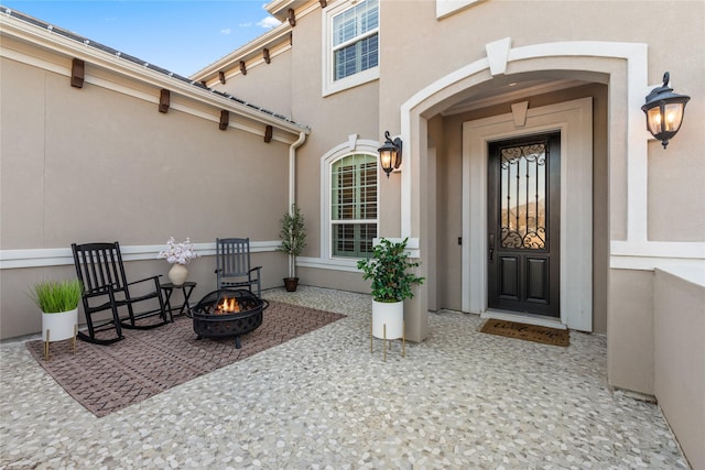 view of exterior entry with a patio area