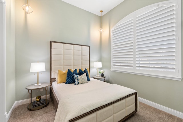 carpeted bedroom featuring multiple windows and baseboards