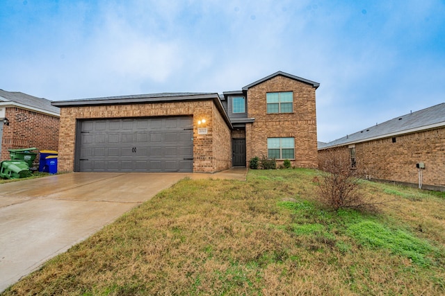 view of front of property featuring a garage and a front lawn