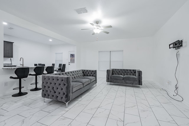 living room featuring ceiling fan and sink