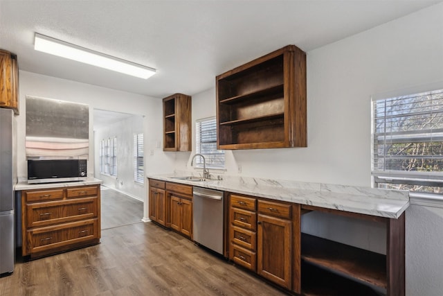 kitchen featuring dark hardwood / wood-style floors, sink, light stone counters, and stainless steel appliances