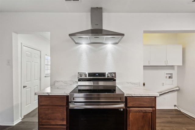 kitchen featuring stainless steel electric range, dark wood-type flooring, wall chimney exhaust hood, ornamental molding, and white cabinetry