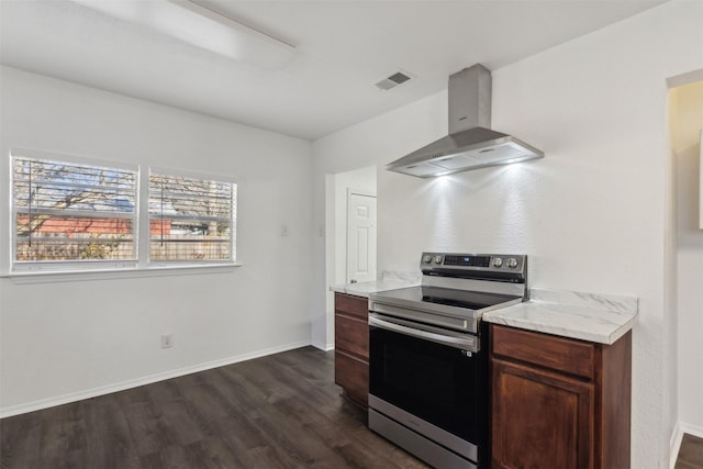 kitchen featuring light stone counters, wall chimney range hood, stainless steel range with electric cooktop, and dark wood-type flooring