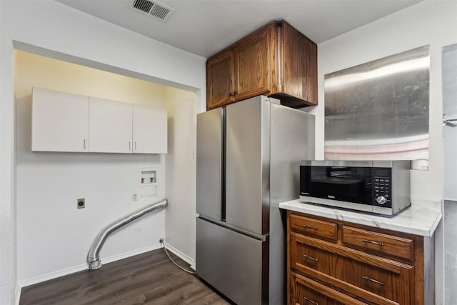 kitchen featuring appliances with stainless steel finishes, white cabinetry, and dark wood-type flooring