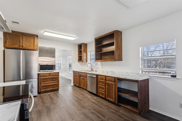 kitchen with light stone counters, dark hardwood / wood-style flooring, sink, and appliances with stainless steel finishes