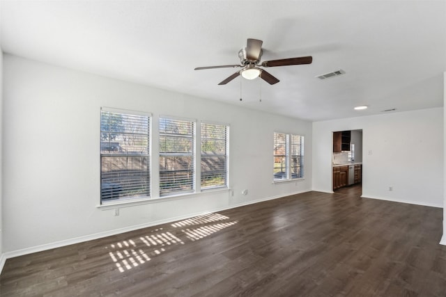 unfurnished living room with ceiling fan and dark wood-type flooring