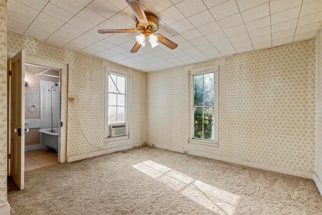 unfurnished bedroom featuring carpet, ceiling fan, cooling unit, and ensuite bath