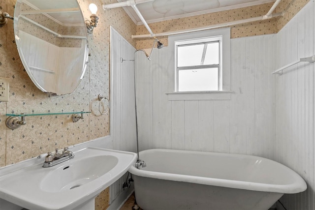 bathroom with a tub to relax in and sink