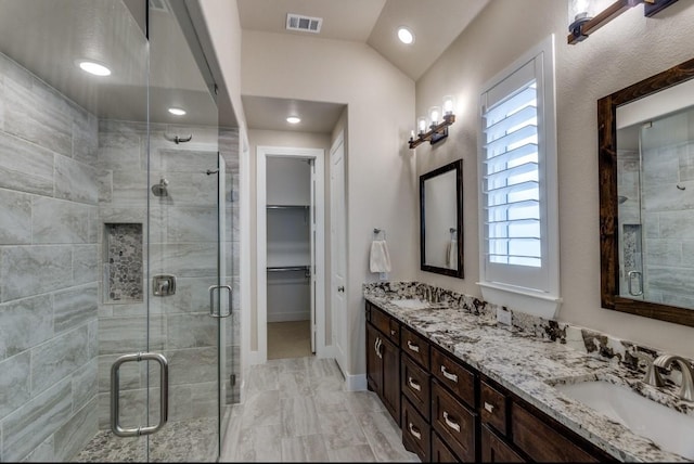 bathroom featuring vanity, vaulted ceiling, and walk in shower