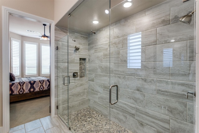 bathroom featuring ceiling fan, tile patterned flooring, and a shower with door