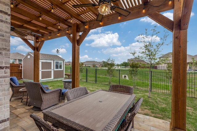 view of patio with ceiling fan and a storage unit