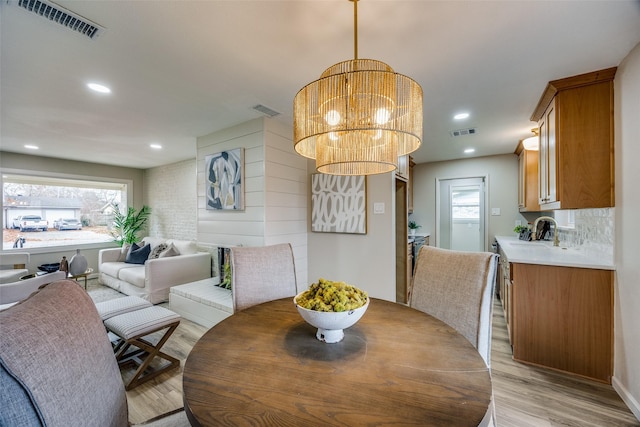 dining room featuring light wood-type flooring, a wealth of natural light, and a chandelier