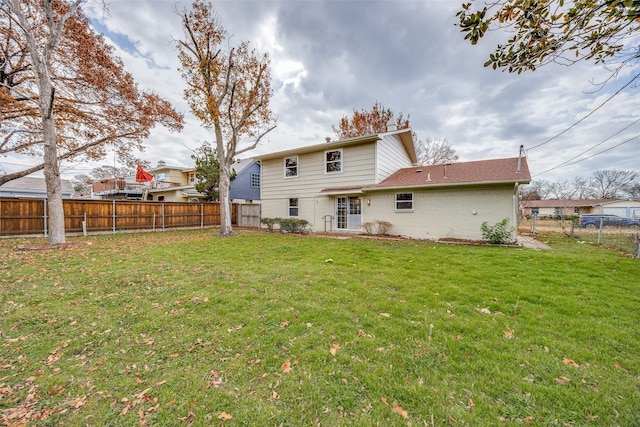 rear view of house featuring a lawn