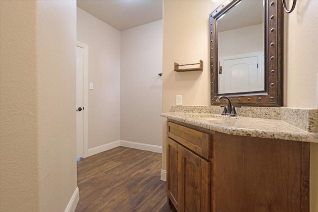 bathroom with vanity, baseboards, and wood finished floors