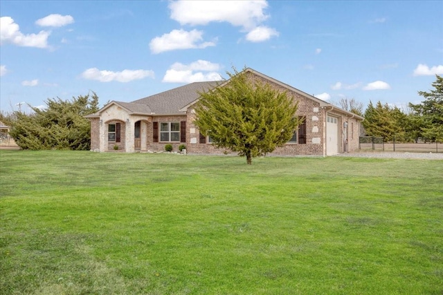 view of front of house featuring a front yard, brick siding, and an attached garage