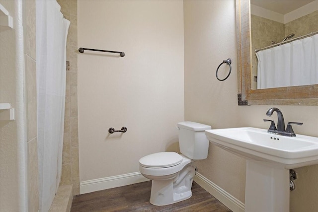 bathroom with curtained shower, toilet, wood-type flooring, and sink