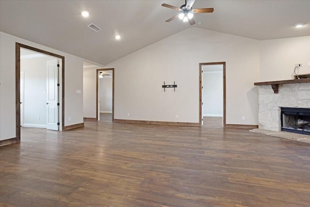 unfurnished living room with vaulted ceiling, ceiling fan, a stone fireplace, and wood finished floors