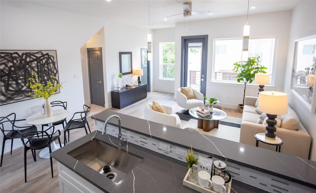 kitchen with sink, light hardwood / wood-style flooring, and decorative light fixtures