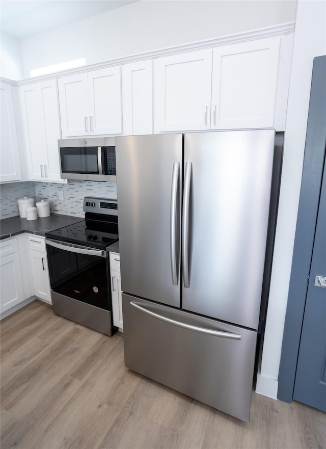 kitchen featuring white cabinetry, decorative backsplash, stainless steel appliances, and light wood-type flooring