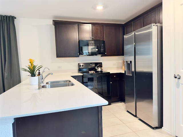 kitchen with dark brown cabinetry, sink, kitchen peninsula, light tile patterned flooring, and black appliances