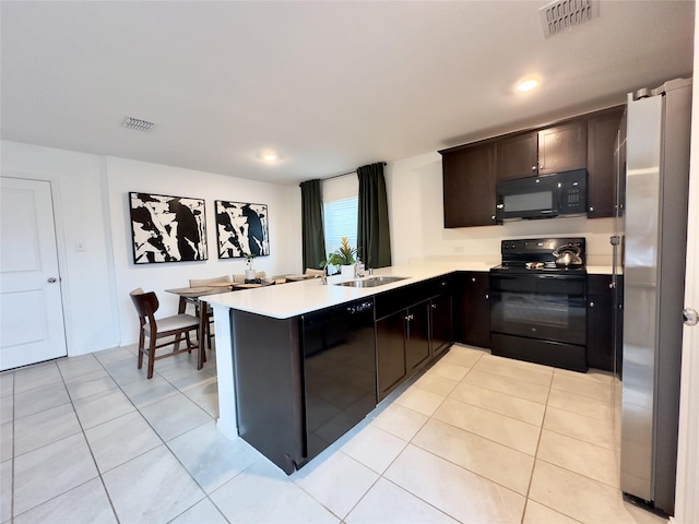 kitchen with black appliances, dark brown cabinets, kitchen peninsula, and light tile patterned floors