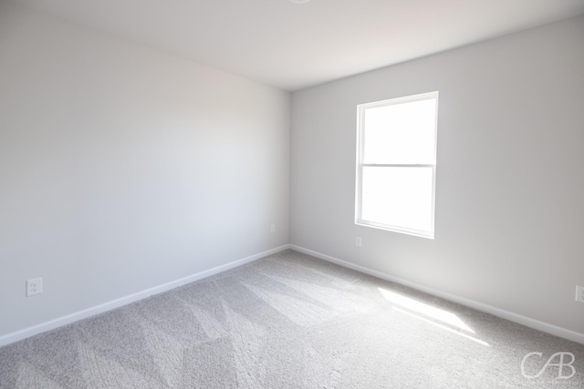 carpeted spare room featuring plenty of natural light