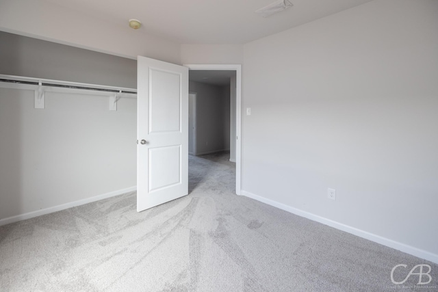 unfurnished bedroom with a closet and light carpet