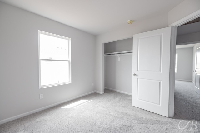 unfurnished bedroom featuring light colored carpet and a closet